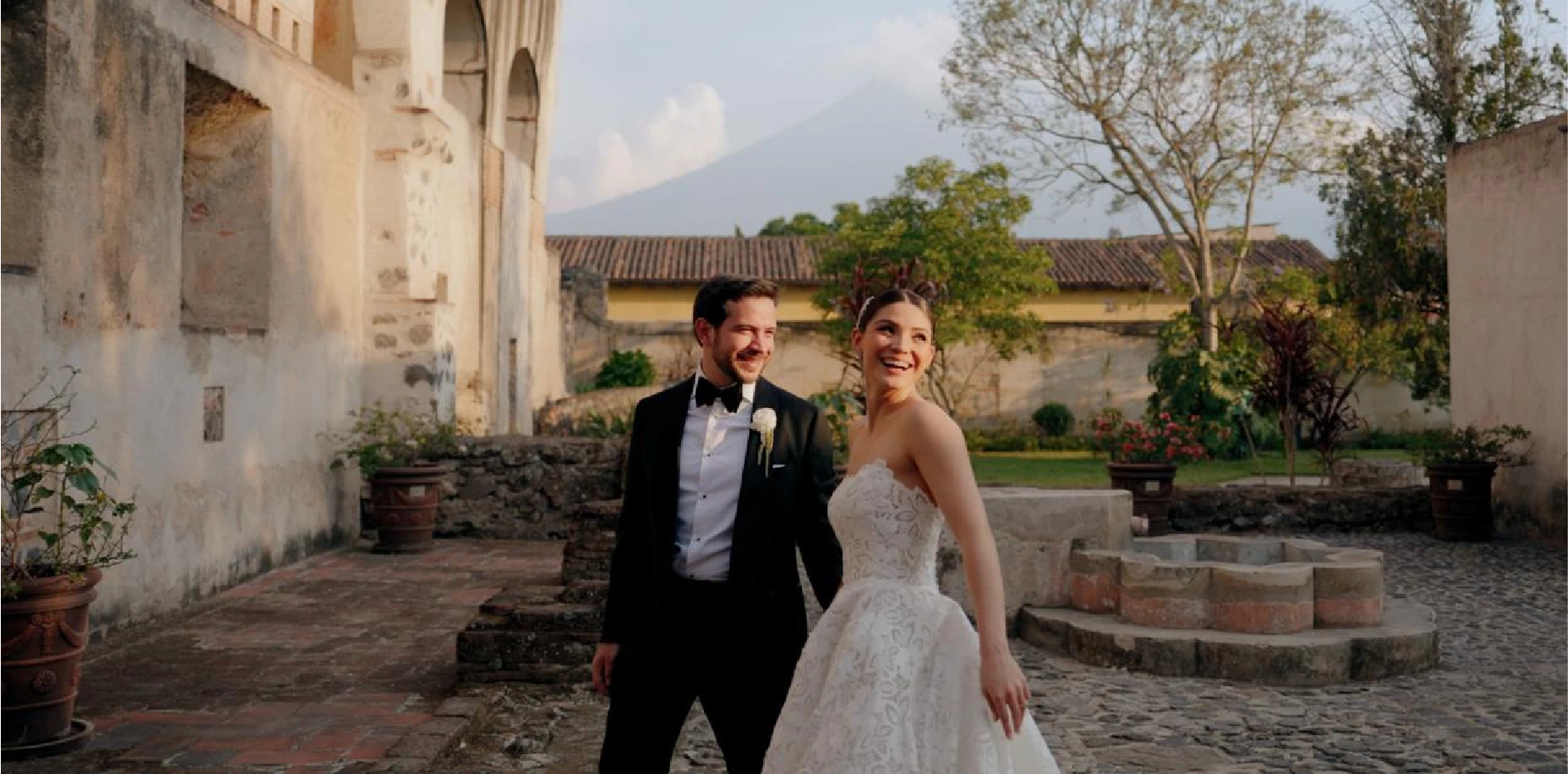 Bride and groom in a colonial courtyard with a volcano view in Antigua Guatemala