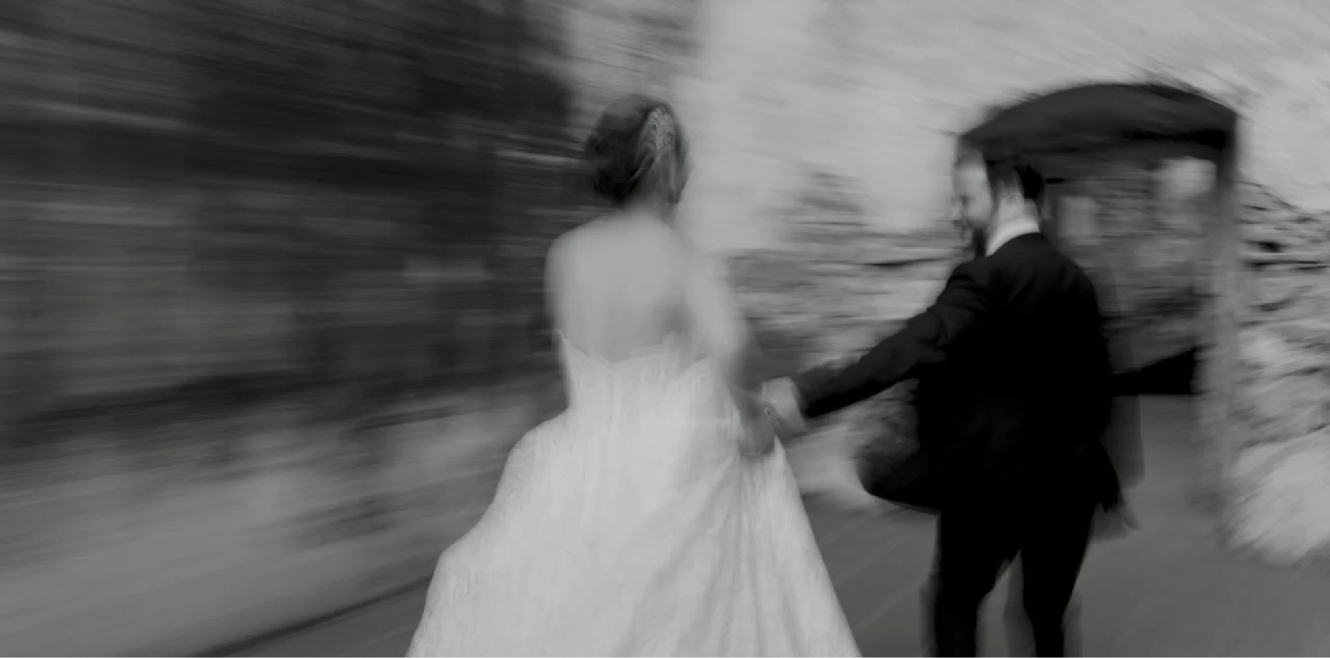 Bride and groom walking in motion, black and white wedding film still