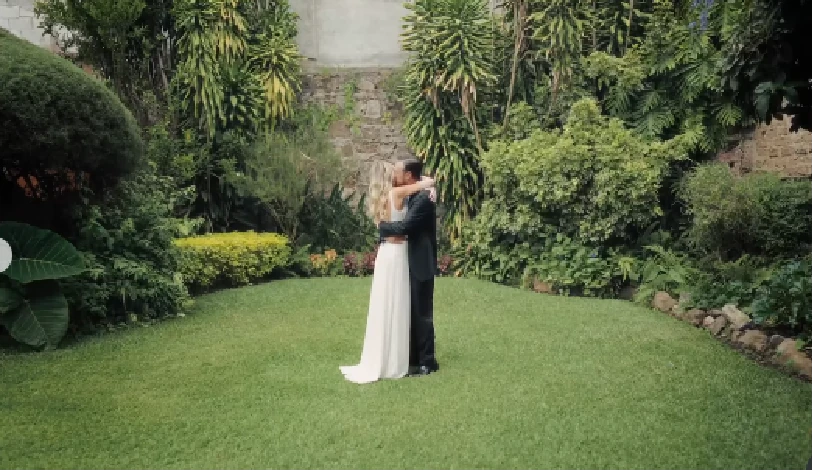 Ana and Martin embracing on the garden lawn at Villa Bokeh