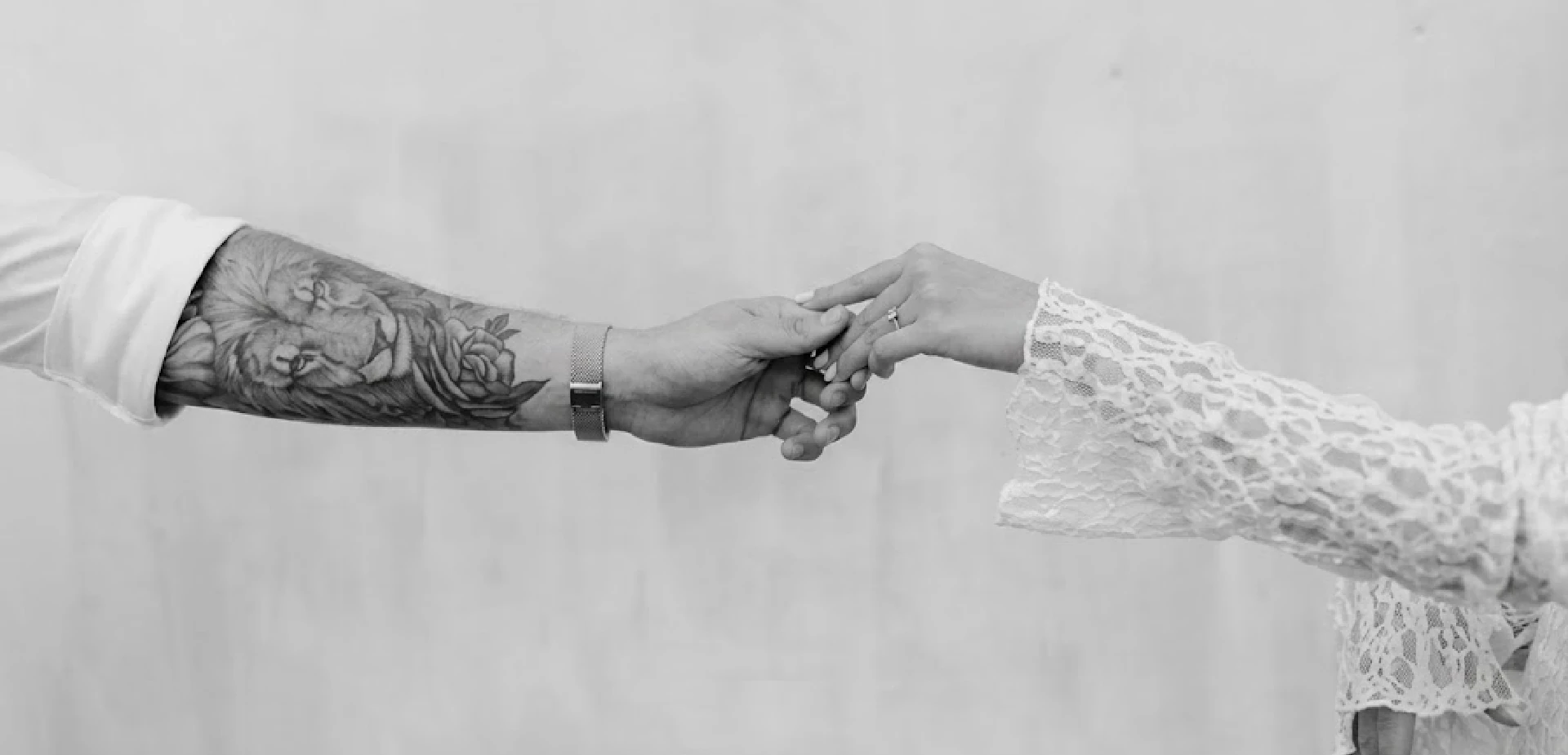 Bride and groom holding hands, black and white detail